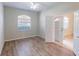 Bedroom featuring wood floors, ceiling fan, and view into the hall at 3097 Royal Palm Dr, North Port, FL 34288