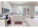 Well-lit kitchen with white cabinetry, stainless steel appliances, and a mosaic backsplash for a modern touch at 3097 Royal Palm Dr, North Port, FL 34288