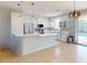 Modern kitchen featuring white cabinets, stainless steel appliances, and a breakfast bar overlooking the pool at 3097 Royal Palm Dr, North Port, FL 34288