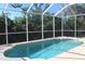 Inviting screened-in pool with clear blue water and lush green surroundings for ultimate relaxation at 3097 Royal Palm Dr, North Port, FL 34288