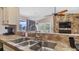 Kitchen features a double sink, tile countertops, and a view to the backyard at 3310 Middletown St, Port Charlotte, FL 33952