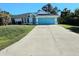 Cute one-story home with a light blue garage door and well-maintained lawn at 6222 Berkeley St, Englewood, FL 34224