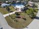 Stunning aerial view of a light pink waterfront home with lush landscaping, palm trees, and a decorative driveway at 649 Maltese Dr, Punta Gorda, FL 33950
