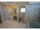 Bathroom featuring patterned wall paper, vanity with mirror, glass block shower and soaking tub at 649 Maltese Dr, Punta Gorda, FL 33950