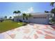 Home featuring a patterned driveway, well-kept lawn, and a two-car garage with water view at 649 Maltese Dr, Punta Gorda, FL 33950