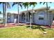 Charming single-story home featuring an arched entryway, well-manicured lawn, and lush palm trees at 649 Maltese Dr, Punta Gorda, FL 33950