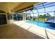 View of screened lanai, pool and hot tub with water view beyond at 649 Maltese Dr, Punta Gorda, FL 33950