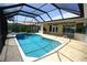 A screened in pool with hot tub and a covered patio with an outdoor kitchen at 649 Maltese Dr, Punta Gorda, FL 33950