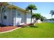 Lovely side yard with well-maintained lawn, mature palm trees and access to the canal at 649 Maltese Dr, Punta Gorda, FL 33950