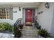 Inviting entryway with a red front door, landscaping, and a gray exterior at 726 Macedonia Dr, Punta Gorda, FL 33950