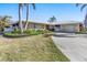 Single-story home with red door, palm trees, and landscaped yard at 838 Santa Margerita Ln, Punta Gorda, FL 33950