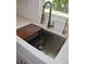 Modern kitchen sink with a butcher block cutting board and stainless steel fixtures at 11278 4Th Ave, Punta Gorda, FL 33955