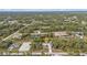 Aerial shot showcases home surrounded by trees; nearby neighborhood visible in distance at 1205 Bartlett Ave, North Port, FL 34288