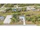 Expansive aerial view of a single-Gathering home with a private pool surrounded by lush greenery in a residential area at 1205 Bartlett Ave, North Port, FL 34288