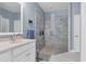 Modern bathroom featuring a glass-enclosed shower with gray tile, with a white sink cabinet and blue walls at 1205 Bartlett Ave, North Port, FL 34288