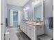 Bathroom showcasing a double vanity with framed mirrors, updated lighting, and a large window at 1205 Bartlett Ave, North Port, FL 34288