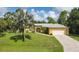 Inviting home with well-maintained lawn, palm trees, and a pristine driveway leading to the garage at 1205 Bartlett Ave, North Port, FL 34288