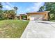 Charming single-story home with a spacious driveway, attached garage, and lush lawn at 1205 Bartlett Ave, North Port, FL 34288