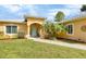 The home's lovely front entrance, featuring a blue door and a well-kept lawn at 1205 Bartlett Ave, North Port, FL 34288