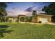Charming single-story home featuring a well-manicured lawn, arched entry, and attached two-car garage at 1205 Bartlett Ave, North Port, FL 34288