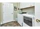 Laundry room area featuring a washer and dryer with tile flooring and white cabinets at 1205 Bartlett Ave, North Port, FL 34288