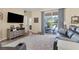 Comfortable living room featuring a sliding glass door to screened patio and backyard pool at 1205 Bartlett Ave, North Port, FL 34288