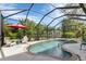 Relaxing screened pool area with comfortable seating and a red umbrella at 1205 Bartlett Ave, North Port, FL 34288
