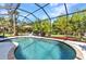 Inviting screened pool surrounded by lush landscaping and ample patio space at 1205 Bartlett Ave, North Port, FL 34288
