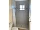Modern bathroom with tiled shower, white toilet, and window at 12090 Malaga Ave, North Port, FL 34287