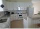 Bright kitchen featuring white cabinetry, granite countertops, and white appliances at 12090 Malaga Ave, North Port, FL 34287