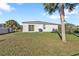 Spacious backyard with mature landscaping and a grill, perfect for outdoor gatherings at 18043 Avonsdale Cir, Port Charlotte, FL 33948