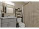 Clean bathroom with gray vanity, shower/tub combo and decorative shelving at 18043 Avonsdale Cir, Port Charlotte, FL 33948