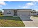 Charming single-story home featuring a well-maintained lawn, two-car garage, and a welcoming entrance at 18043 Avonsdale Cir, Port Charlotte, FL 33948