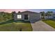 Inviting single-story home featuring a well-manicured lawn, a two-car garage and driveway, and easy to maintain landscape at 18043 Avonsdale Cir, Port Charlotte, FL 33948