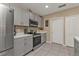 Charming kitchen with stainless steel appliances, gray cabinetry, and a tile floor at 18043 Avonsdale Cir, Port Charlotte, FL 33948