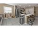 Bright kitchen features stainless appliances, gray cabinets, and a breakfast bar with seating at 18043 Avonsdale Cir, Port Charlotte, FL 33948