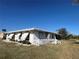 Side view of a single story home with white exterior and small fence at 21062 Edgewater Dr, Port Charlotte, FL 33952