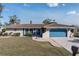 Single-story home with a blue garage door and well-maintained landscaping at 2910 Guadalupe Dr, Punta Gorda, FL 33950