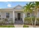 Inviting front porch with seating, a black front door, and lush landscaping at 3119 Amanda St, Punta Gorda, FL 33950