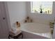Bathroom with soaking tub, decorative tile accents, and frosted glass window at 4692 Hillman Ter, North Port, FL 34288