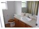 Bathroom with wooden cabinets, white sink, and tiled floor at 4692 Hillman Ter, North Port, FL 34288