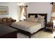 Bedroom with king-size bed, loveseat, and elegant furnishings at 4692 Hillman Ter, North Port, FL 34288