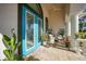 Inviting entryway with teal double doors, a welcoming porch, and lush landscaping at 5541 Almar Dr, Punta Gorda, FL 33950