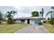Front exterior of a single-story home with a driveway, landscaping, and palm trees at 11332 8Th Ave, Punta Gorda, FL 33955