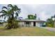 Front exterior of a single-story home with a driveway, some landscaping and palm trees at 11332 8Th Ave, Punta Gorda, FL 33955