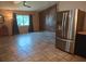 Open concept kitchen and living area with tile floors, natural light, and stainless steel refrigerator at 11332 8Th Ave, Punta Gorda, FL 33955