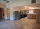 Eat-in kitchen with stainless steel appliances, wooden cabinetry and tile flooring at 11332 8Th Ave, Punta Gorda, FL 33955