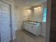 Elegant bathroom featuring double sinks, granite countertops, and modern lighting fixtures at 13480 Allentown Ave, Port Charlotte, FL 33981