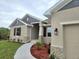 Tan stucco home with gray accents, brown shutters, stone accents, and manicured landscaping at 13480 Allentown Ave, Port Charlotte, FL 33981