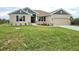 Charming single-story home with tan stucco, gray accents, brown shutters, and a well-manicured lawn at 13480 Allentown Ave, Port Charlotte, FL 33981